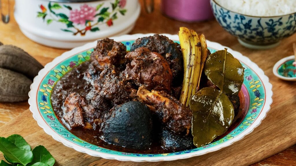 Peranakan Food Heritage SG : Ayam Buah Keluak, a rich curry blending earthy keluak nuts with tender chicken.