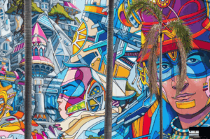 Vibrant mural painted on a large wall along Victoria Street in Little India, part of the dynamic Singapore art scene where street art, urban art, and graffiti by local and international artists transform public spaces into open‑air art exhibitions. This striking visual arts piece blends art deco influences with traditional motifs, echoing works seen at the Singapore Art Museum, National Gallery Singapore, and during the Singapore Biennale. The composition reflects art forms from fine arts to performing arts, inspired by culture, history, and the multicultural society of Singapore—a young nation in the Asia Pacific region and Southeast Asia. Surrounded by boutique shops, main streets, and neighbourhood landmarks like Haji Lane, Clive Street, Kerbau Road, Rowell Road, and Ann Siang Hill, the scene recalls the modern way artists such as Yip Yew Chong, Ernest Zacharevic, and Novena Angela have helped develop art in Singapore. The imagery nods to Chinese immigrants, India, China, and Asia, weaving in food, music, and life as part of the city’s important role in global art. References to Tiong Bahru, Chinatown, the central business district, and even pop culture like Crazy Rich Asians highlight how shops, streets, and events connect early exhibitions to the new generation of emerging artists. This modern city’s contemporary scene features sculptures, collection highlights, and inspired ideas showcased at Art SG, the Nanyang Academy, and venues supported by the National Heritage Board, making it a must‑visit for those who want to find street art in Singapore and explore its world of creativity.