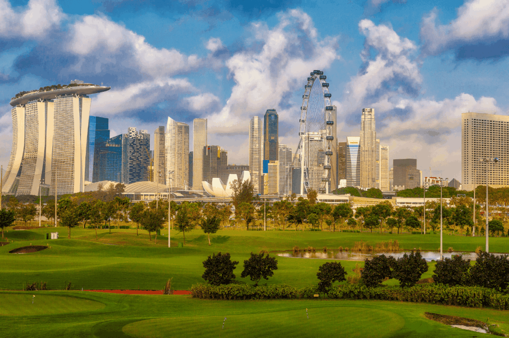 Panoramic view of Marina Bay in Singapore with the iconic Marina Bay Sands hotel, Singapore Flyer, and lush golf course foreground, showcasing the blend of nature lovers’ spaces and modern city living in the melting pot of Singapore neighbourhoods. Easily accessible and easily accessed with easy access from Changi Airport, this bustling area is within walking distance to numerous restaurants, hawker stalls serving good food, bars, malls, and shopping streets. Visitors can explore local Peranakan culture, colourful shophouses, and cultural attractions in Chinatown, Kampong Gelam, Little India, Joo Chiat, Tiong Bahru, Holland Village, Robertson Quay, Clarke Quay, Orchard Road, and the financial district. From fresh produce markets in residential area houses of Bukit Timah, Bukit Batok, Bukit Panjang, Pasir Ris, and Paya Lebar, to Sentosa Island resorts, Sentosa Cove hotels, and East Coast Park, each neighbourhood offers unique culture, history, and nightlife. Highlights include the Singapore River, Singapore Zoo, Dempsey Hill dining, Eastpoint Mall, and neighbourhoods popular with young couples, expats, and residents. This guide to the country’s towns invites travellers to walk, visit, explore, and indulge in the best neighbourhoods located north, south, east, and west, filled with world-class attractions, island escapes, and rich cultural heritage.