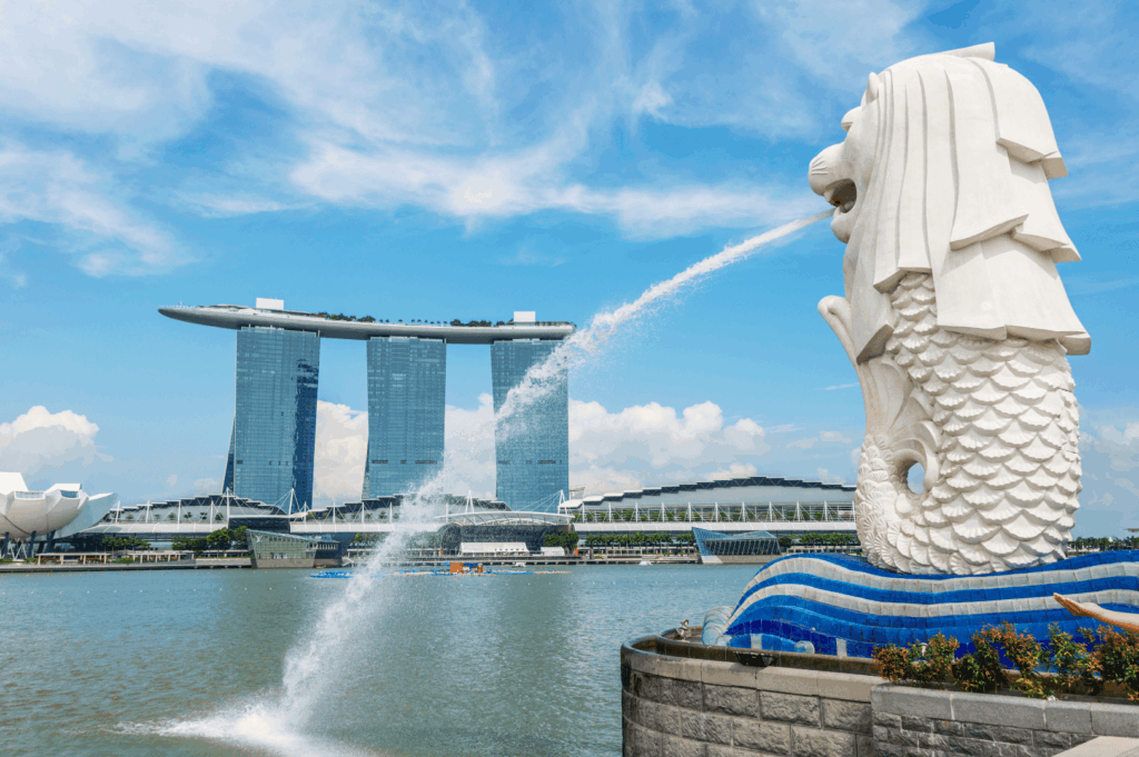 Iconic Merlion statue spouting water into Marina Bay with Marina Bay Sands hotel in the background, symbolizing the vibrant melting pot of Singapore neighbourhoods. This bustling area in the city is easily accessible and easily accessed with easy access from Changi Airport, and within walking distance to numerous restaurants, hawker stalls serving good food, bars, malls, and shopping streets. Visitors can explore local Peranakan culture, colourful shophouses, and cultural attractions in Chinatown, Kampong Gelam, Little India, Joo Chiat, Tiong Bahru, Holland Village, Robertson Quay, Clarke Quay, Orchard Road, and the financial district. From fresh produce markets in residential area houses of Bukit Timah, Bukit Batok, Bukit Panjang, Pasir Ris, and Paya Lebar, to nature lovers’ escapes at East Coast Park, Sentosa Island, and Sentosa Cove hotels, each neighbourhood offers unique culture, history, and nightlife. Highlights include the Singapore River, Singapore Zoo, Dempsey Hill dining, Eastpoint Mall, and neighbourhoods popular with young couples, expats, and residents. This guide to the country’s towns invites travellers to walk, visit, explore, and indulge in the best neighbourhoods located north, south, east, and west, filled with world-class attractions and rich cultural heritage.