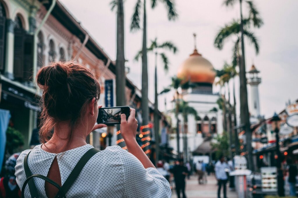 Exploring Kampong Glam Heritage : Traveller admiring vibrant street art in Kampong Glam’s heritage lanes.