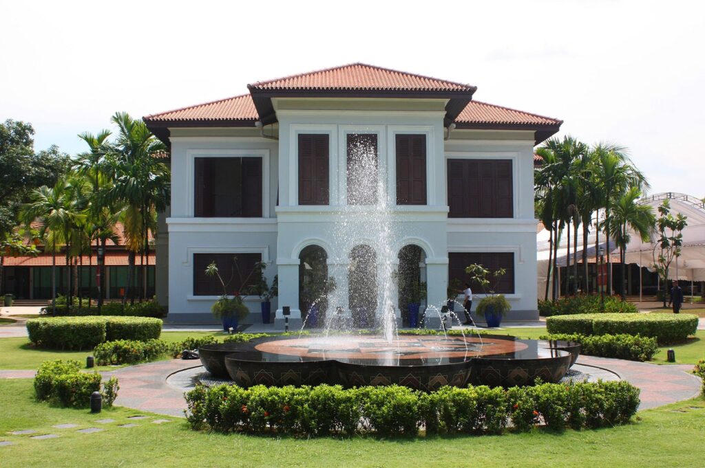 The historic Istana Kampong Glam (Malay Heritage Centre), a grand white colonial-style palace with a red roof and a decorative fountain in the manicured front lawn.