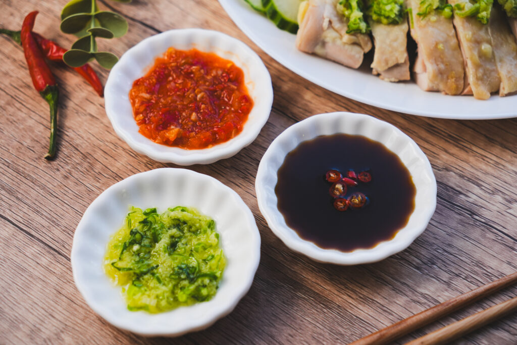 Hainanese Chicken Rice Singapore : A vibrant trio of condiments symbolising balance, spice, and depth in Singapore’s national dish.