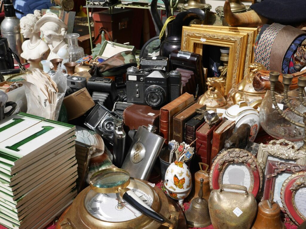 Community Markets Singapore : Shoppers browsing vintage clothes and antiques at a bustling flea market.