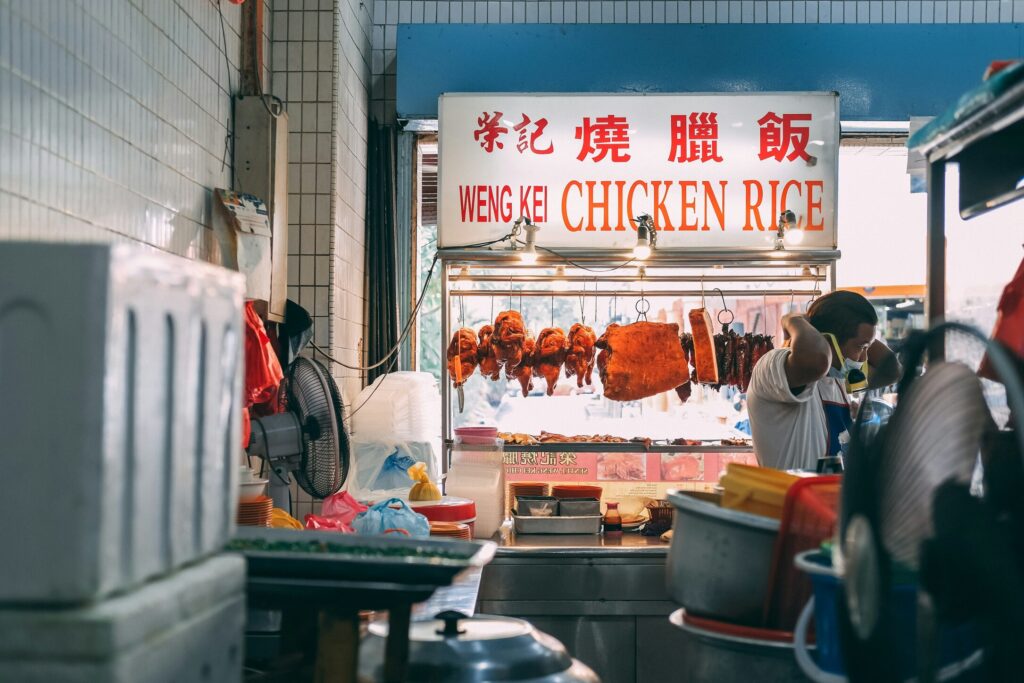 Hainanese Chicken Rice Singapore : Food lovers savouring Singapore’s most beloved chicken rice at a bustling hawker centre.
