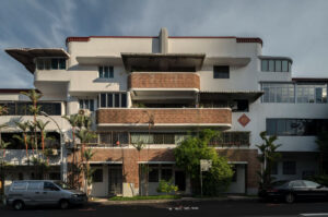 Exterior view of a pre-war, low-rise residential block in Singapore (likely Block 81 in Tiong Bahru) featuring classic Art Deco Streamline Moderne architecture with curved walls and brick accents.