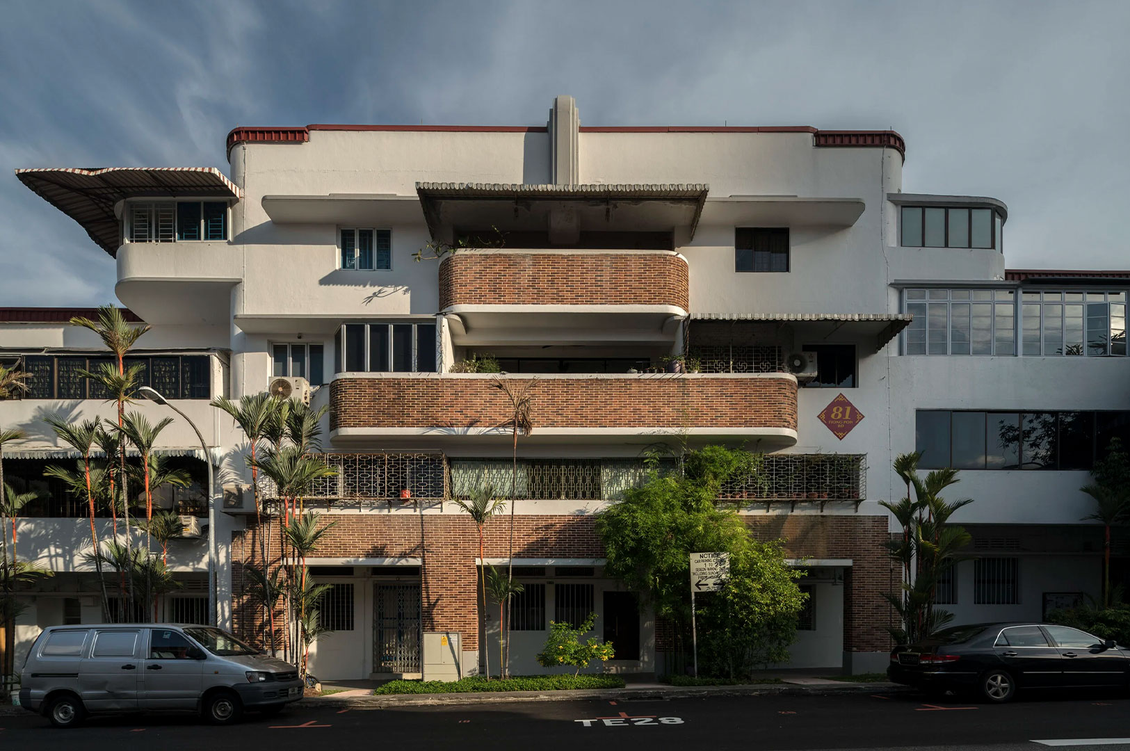 Exterior view of a pre-war, low-rise residential block in Singapore (likely Block 81 in Tiong Bahru) featuring classic Art Deco Streamline Moderne architecture with curved walls and brick accents.