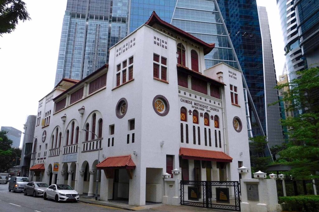 Chinese Methodist Church Singapore with traditional Chinese architectural style, tiled roof, circular windows, red accents, and facade inscription 'Established 1885'.