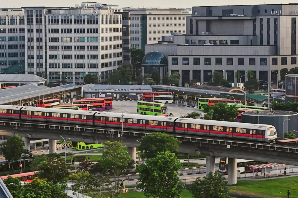 Public transport hub in Tampines Regional Centre showing an elevated MRT train, bus interchange, and surrounding commercial buildings in Singapore.