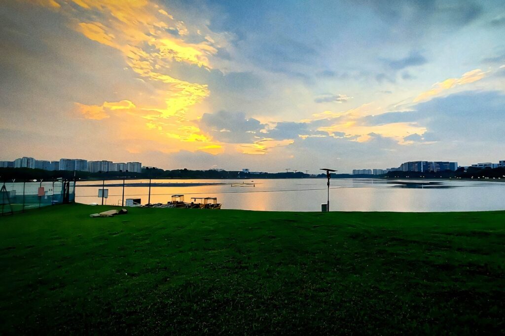 Sunset view over Bedok Reservoir with glowing clouds and calm water.