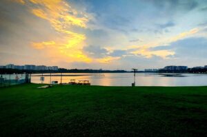 Sunset view over Bedok Reservoir with glowing clouds and calm water.