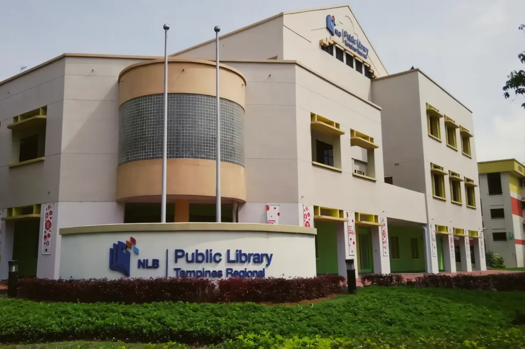 Tampines Regional Library in Singapore featuring a modern public building with clean architectural lines, greenery, and the National Library Board signage.