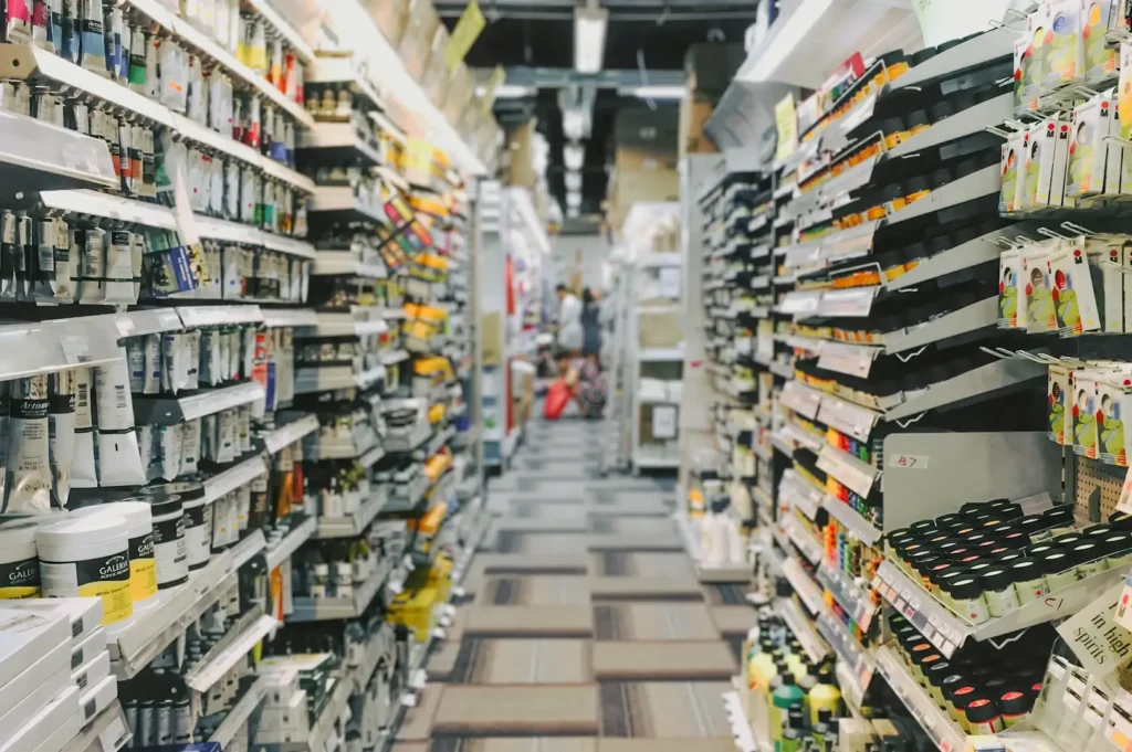 Retail store aisle filled with neatly arranged art and craft supplies, showcasing paints, brushes, and creative materials on well‑stocked shelves.