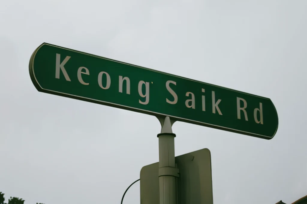 Close-up low-angle photograph of a Keong Saik Road street sign, highlighting the street name associated with Singapore’s urban heritage.