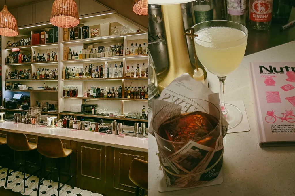 Left: Eye-level, wide-angle view of a modern bar interior with a long wooden counter, cushioned bar stools, geometric tiled flooring, and wall-to-ceiling shelves filled with assorted liquor bottles and glassware, illuminated by warm pendant lights and soft recessed lighting that highlight clean lines and textured surfaces. Right: Close-up, slightly top-down shot of a pale yellow cocktail in a stemmed coupe glass with a small garnish on a pick, placed beside a wrapped container holding a dark beverage and a printed magazine or menu on a light countertop, with warm lighting emphasizing reflective glass surfaces and layered textures.
