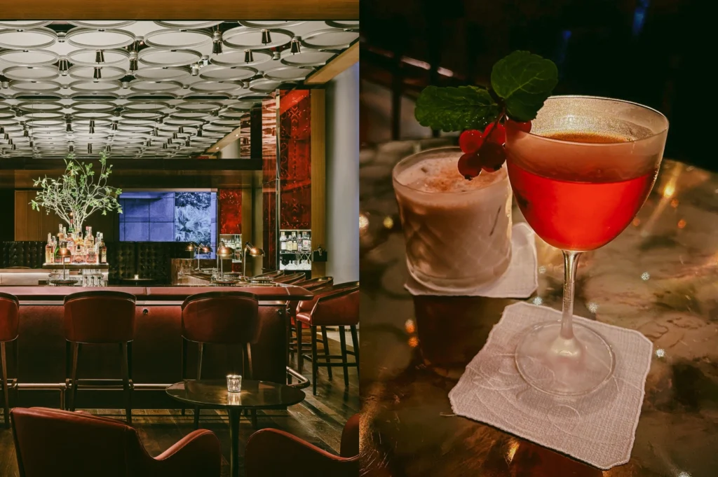 Left: An eye-level, wide-angle shot of an upscale, modern lounge bar featuring deep red leather barstools lined along a dark counter. The venue is distinguished by a geometric patterned ceiling of interlocking white rings and a back bar display accented with rich red paneling, small desk lamps, and a potted green branch. Right: A close-up, three-quarter view of two cocktails resting on white fabric coasters atop a reflective polished tabletop. In the foreground, a vibrant red cocktail in a stemmed coupe glass is garnished with fresh green mint leaves and red currants, while a textured glass containing a creamy, light-colored beverage sits softly blurred behind it.