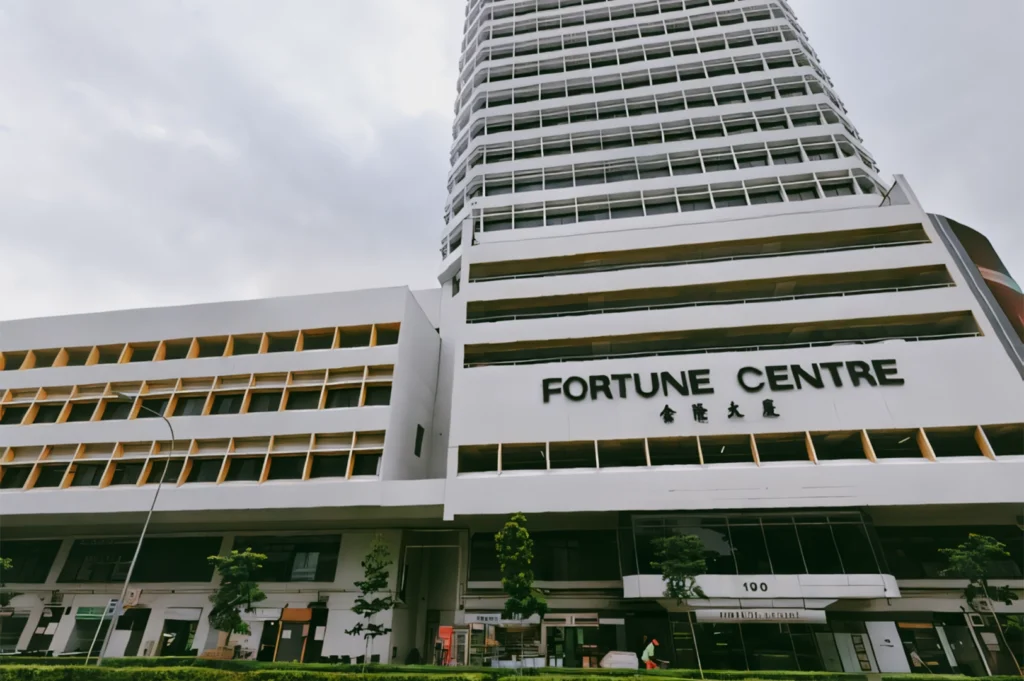 Low-angle wide shot of Fortune Centre building exterior in Singapore, showcasing multi-storey facade and entrance of popular hidden food hub