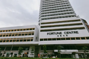 Low-angle wide shot of Fortune Centre building exterior in Singapore, showcasing multi-storey facade and entrance of popular hidden food hub
