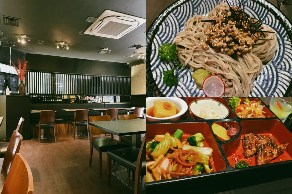 “Wide-angle, eye-level view. Left: Herbivore restaurant dining area with dark walls, wooden flooring, black tables, wooden chairs, booth seating, ceiling spotlights, and a modern minimalist interior under warm ambient lighting. Upper Right: Top-down close-up of cold natto soba served in a patterned bowl, topped with natto, sesame seeds, shredded seaweed, parsley, wasabi, and a sliced radish, showcasing the noodles’ smooth texture and neat presentation. Lower Right: Three-quarter close-up of an unagi stir-fry bento arranged in a compartment tray with grilled glazed slices, mixed vegetables, salad, side dishes, and dessert, highlighting colorful ingredients and organized composition.”