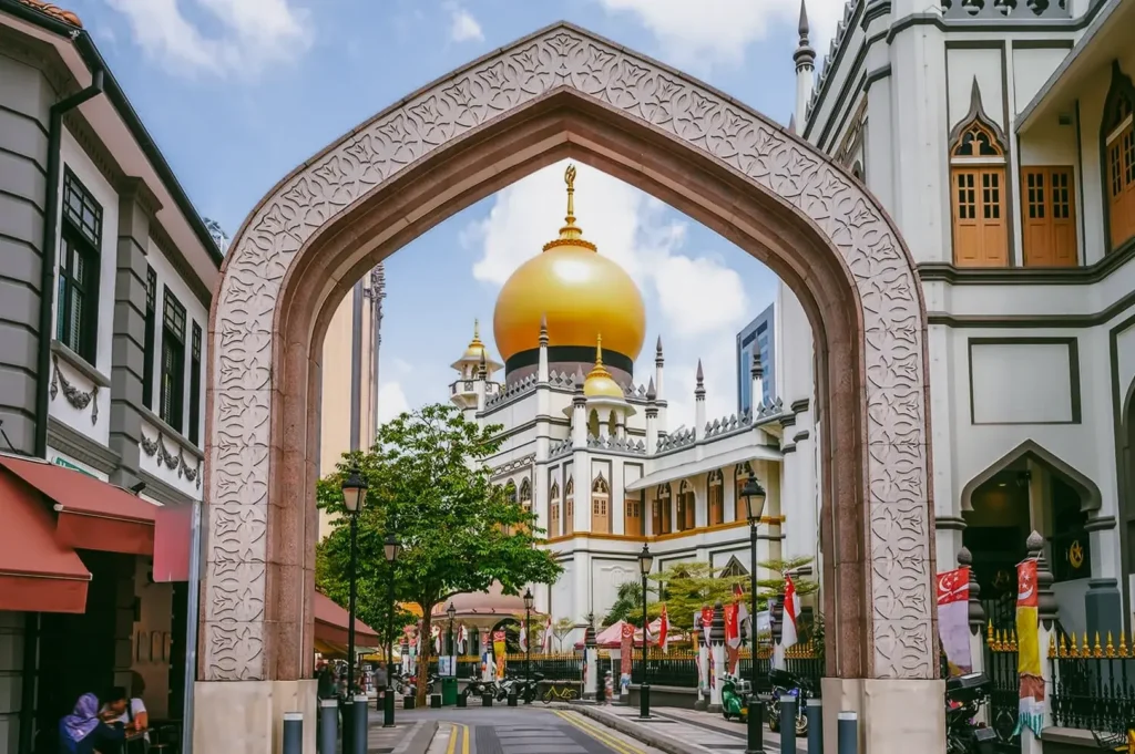 Street-level shot framed by an archway revealing a mosque dome in Kampong Glam, highlighting Singapore’s neighborhood culture and weekend dining districts.