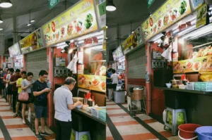 Split image showing a busy lunch queue at a Singapore hawker stall on a weekday contrasted with a quieter weekend lunchtime scene.