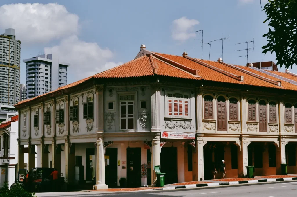Eye-level corner view of a conserved heritage shophouse in Tanjong Pagar with ornate façades and traditional shutters, reflecting the neighborhood’s living architectural history