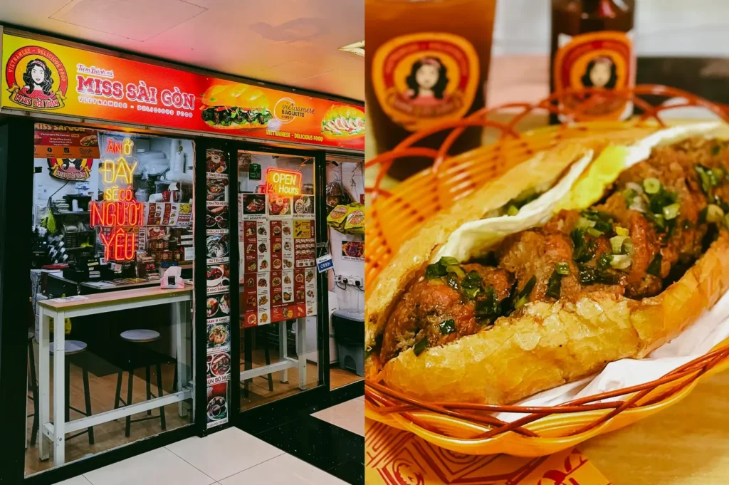 Left: Eye-level storefront view of ‘Miss Saigon’ Vietnamese restaurant with bright orange signage, illuminated menu boards, glass entrance, and neon ‘open 24 hours’ sign in a compact indoor mall setting; Right: Close-up three-quarter angle of a Vietnamese banh mi sandwich filled with grilled meat, herbs, and vegetables in a crisp baguette, served in a basket with branded paper and bottled drinks blurred in the background.