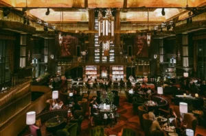 Wide-angle symmetrical interior shot of ATLAS Bar Singapore showing grand Art Deco design, gin tower and luxury cocktail bar in Parkview Square