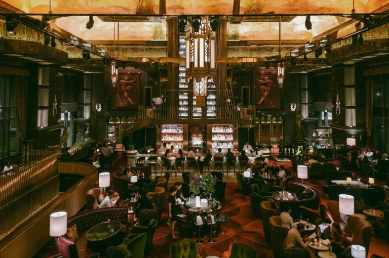 Wide-angle symmetrical interior shot of ATLAS Bar Singapore showing grand Art Deco design, gin tower and luxury cocktail bar in Parkview Square