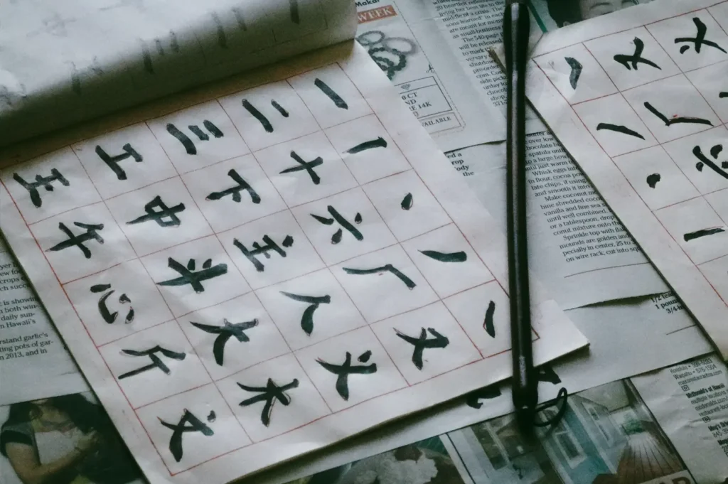 Close-up top-down shot angle of practice sheets with Chinese calligraphy strokes and a brush on paper, emphasizing skill development, ink technique, and mindful repetition in traditional writing art.