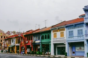 Eye-level wide street shot of colorful heritage shophouses along Little India Singapore, featuring traditional architecture and cultural district streetscape in daytime