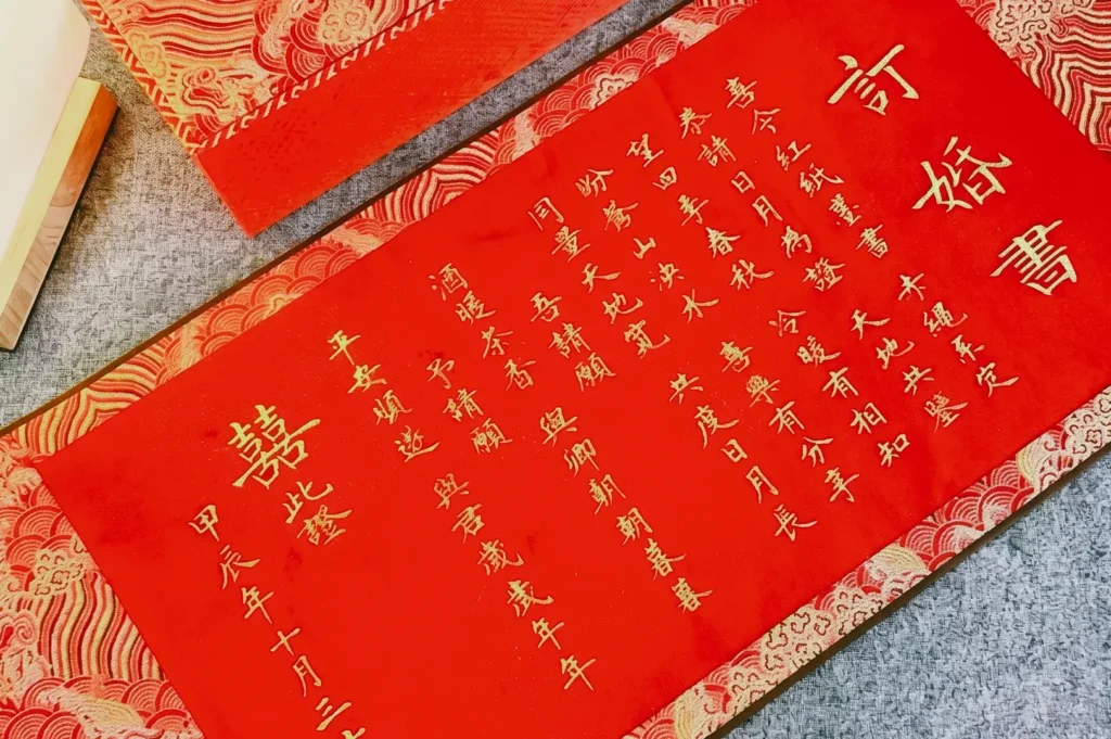 High-angle diagonal shot angle of a red Chinese calligraphy scroll with gold characters, emphasizing festive traditions, cultural symbolism, and traditional writing art.