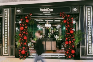 Violet Oon ION Orchard entrance with festive decor and elegant Peranakan-inspired facade, captured at eye-level frontal wide shot on Orchard Road Singapore