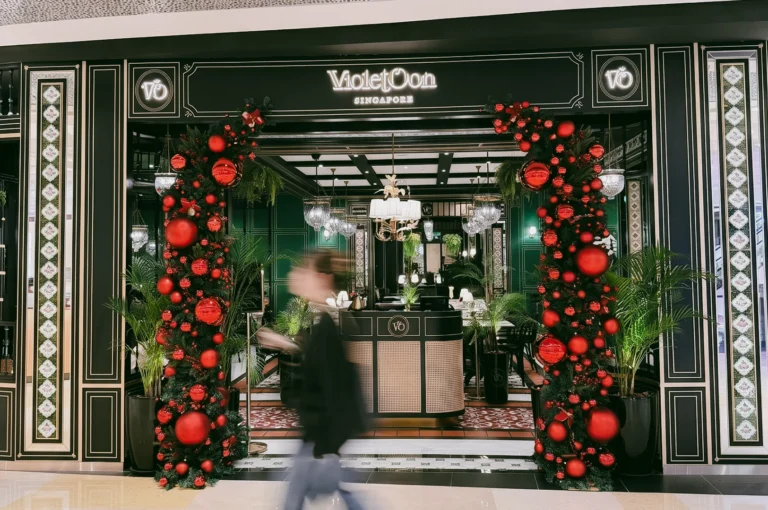 Violet Oon ION Orchard entrance with festive decor and elegant Peranakan-inspired facade, captured at eye-level frontal wide shot on Orchard Road Singapore
