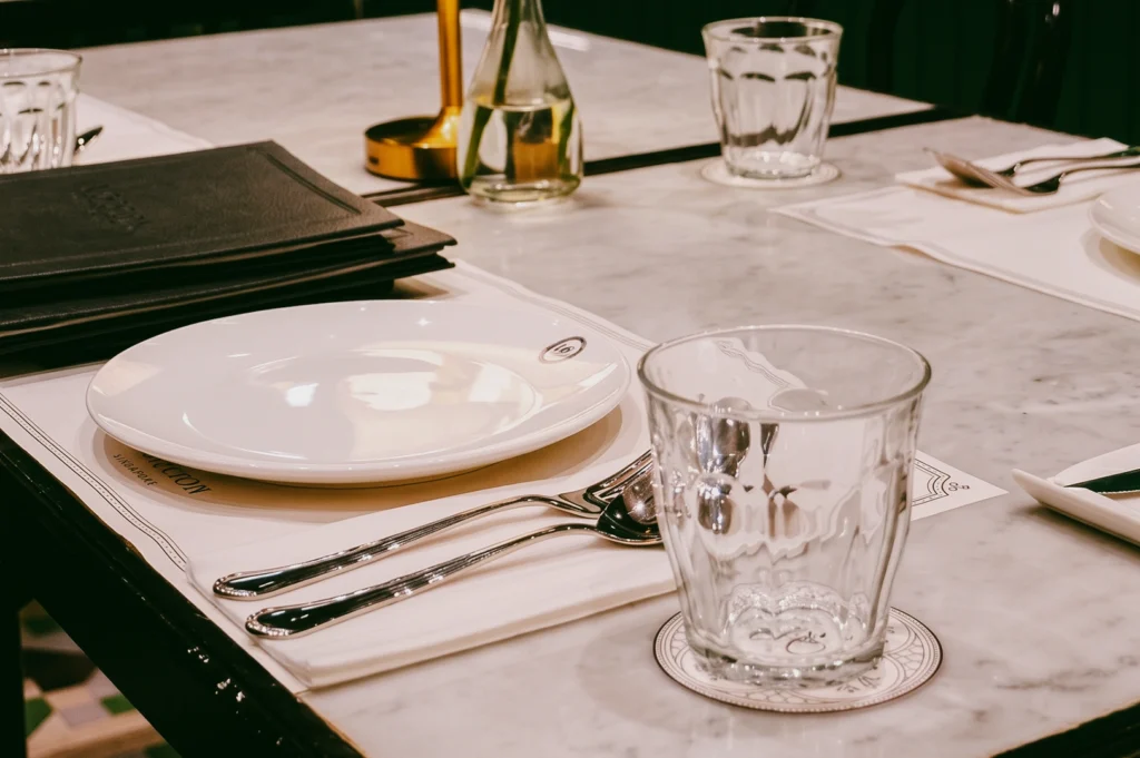 Elegant table setting at Violet Oon ION Orchard with marble table and heritage dining details, captured in eye-level shallow depth interior shot