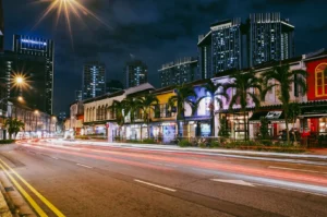 Long-exposure street-level shot of colorful shophouses and traffic light trails in Tanjong Pagar nightlife district Singapore