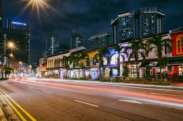 Long-exposure street-level shot of colorful shophouses and traffic light trails in Tanjong Pagar nightlife district Singapore