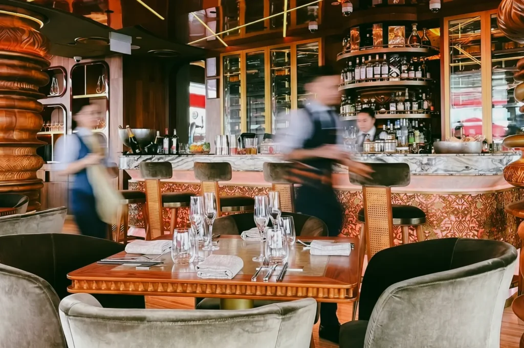 Wide-angle interior view of CÉ LA VI rooftop restaurant bar showcasing luxury dining space, cocktail shelves, and modern design